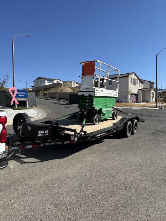A scissor lift secured on our trailer at a new home development. It’s a good fit for contractors and anyone moving heavy equipment between job sites.